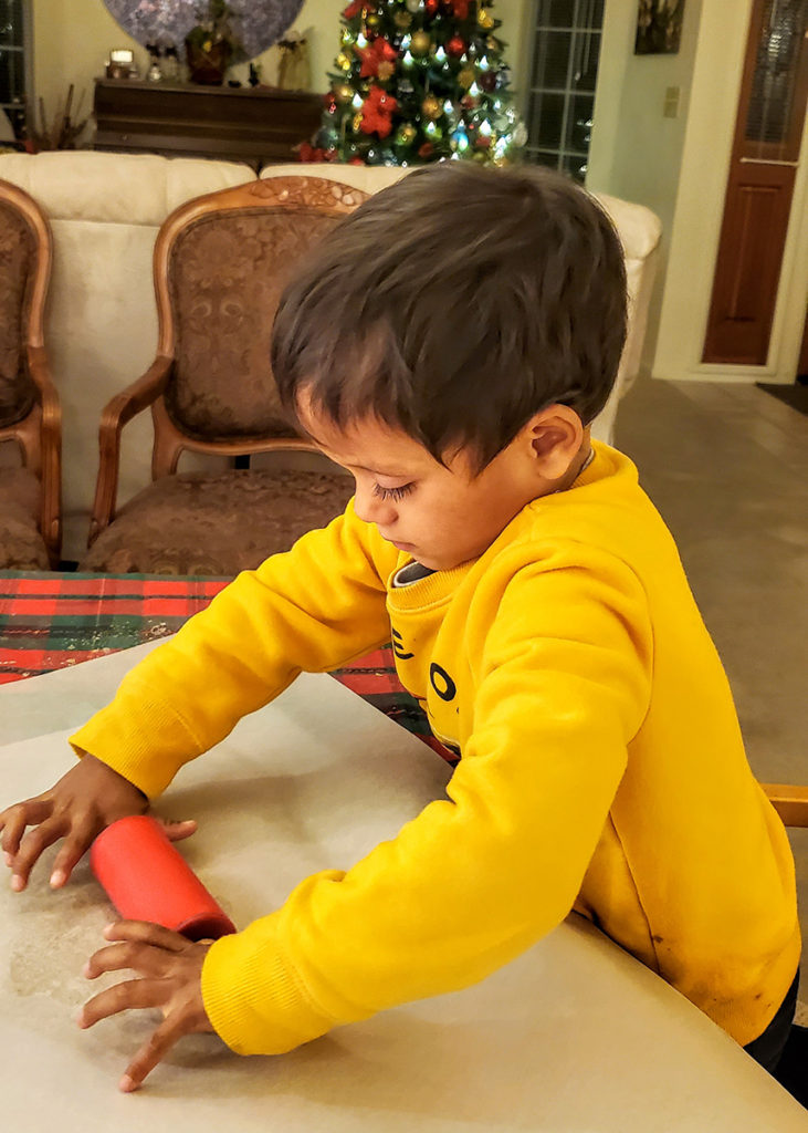 my son rolling christmas cookies